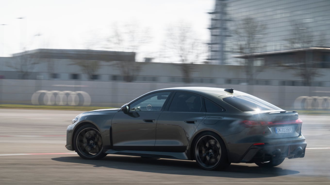 Ein neuer Audi RS5 in der Farbe Bedford-Grün rast über ein Testgelände