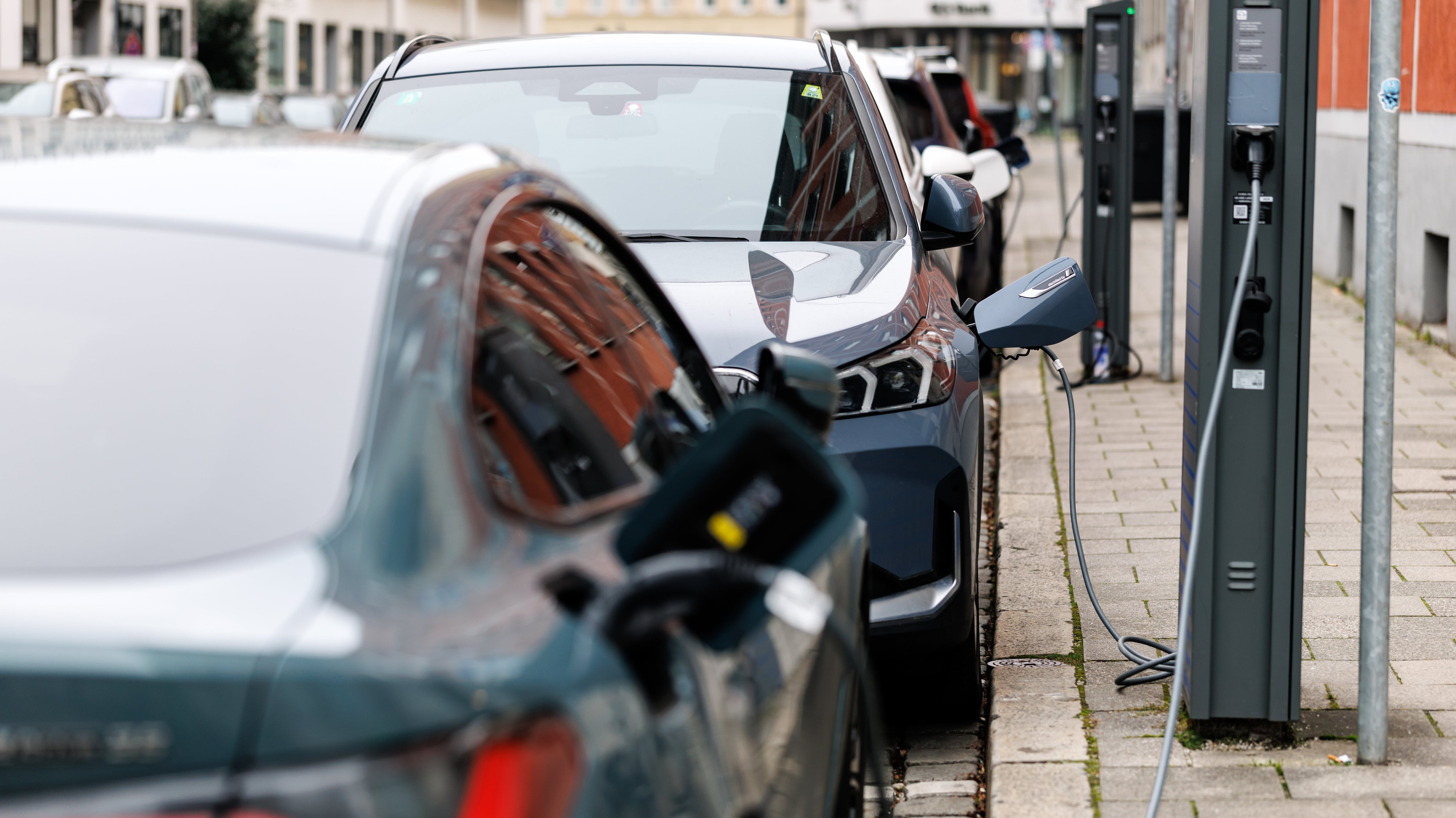 Elektroautos verschiedener Hersteller sind in Ladesäulen in München.