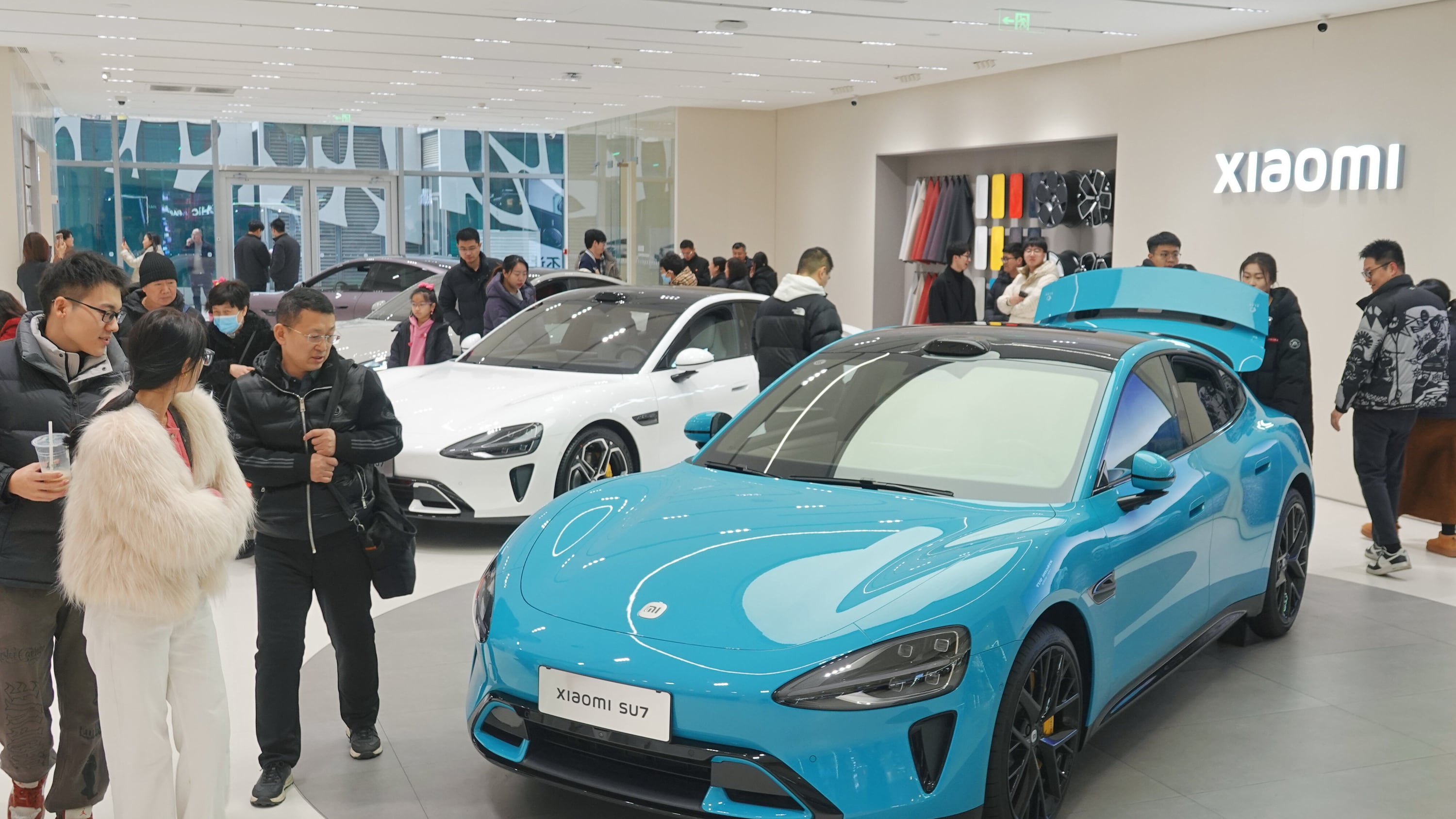 YANTAI, CHINA Kunden in einem Showroom von Xiaomi sehen sich einen Mi SU7 an.