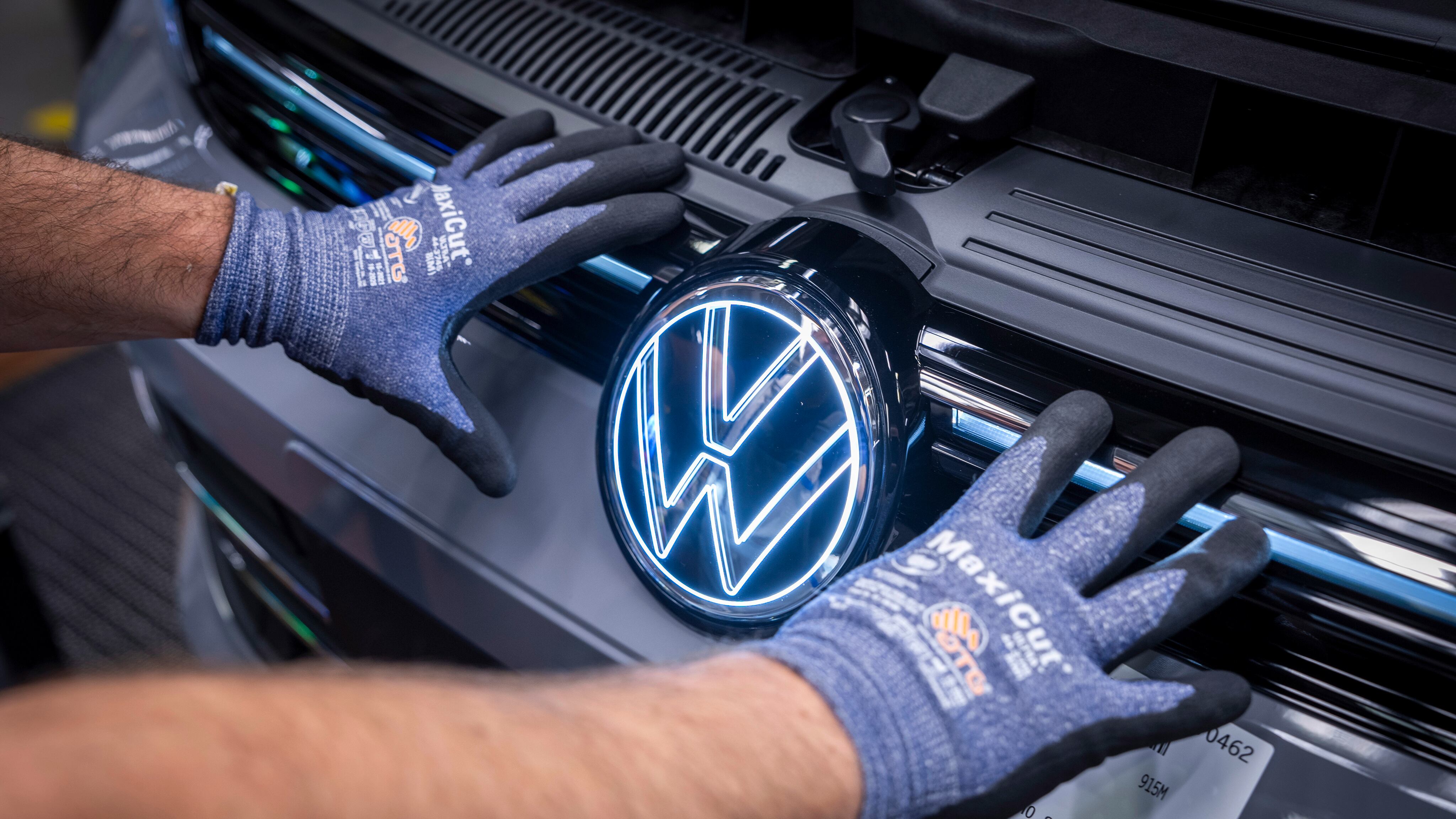 Nahaufnahme: Ein Mitarbeiter von VW arbeitet an einem neuen VW Golf