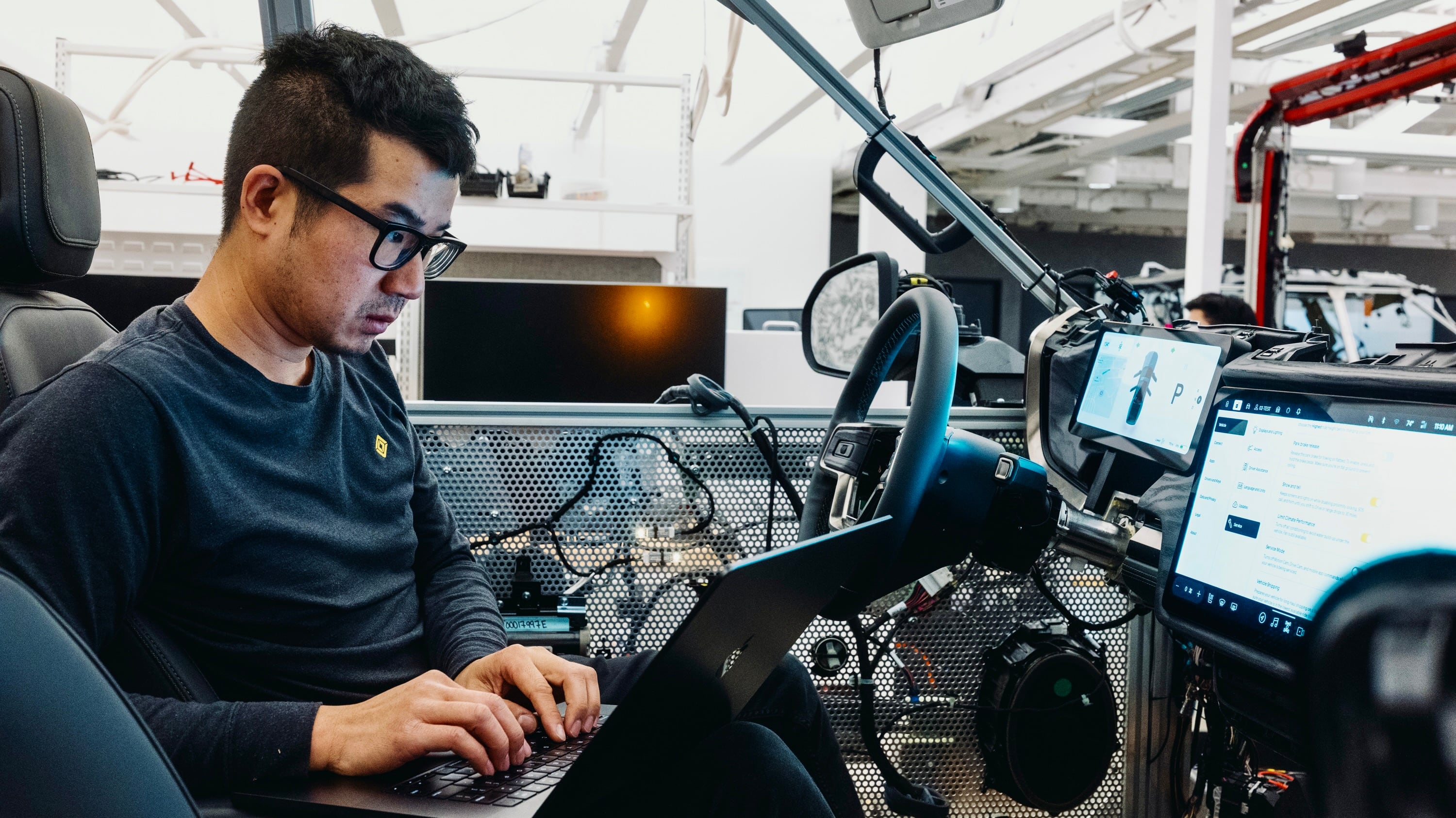 A engineer with Rivian and VW's joint venture, RVTech, sits in a "lab car" testing software in Silicon Valley.