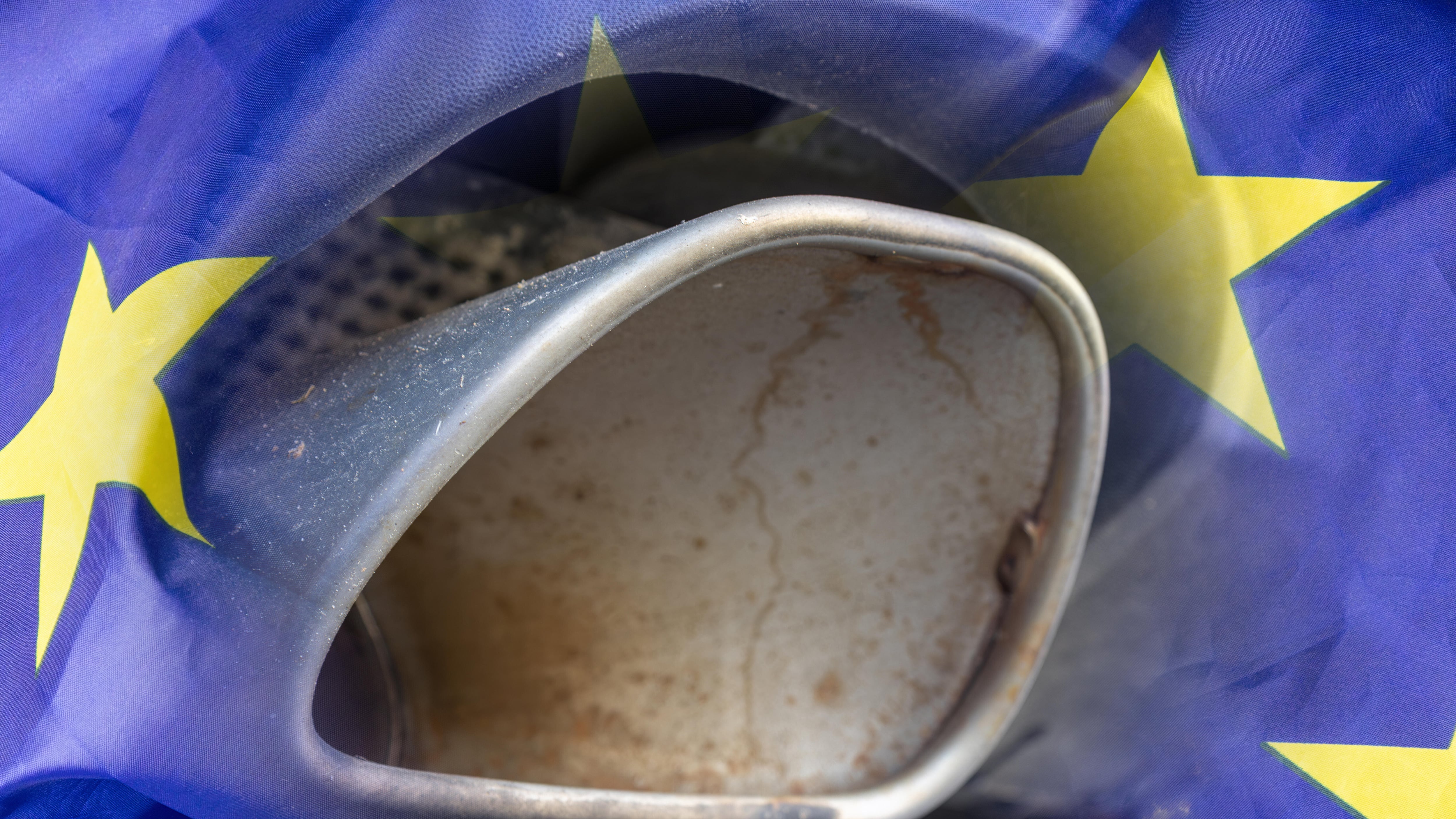 Fotomontage Verbrenner-Aus: Auspuff eines SUV und eine Flagge der Europäischen Union