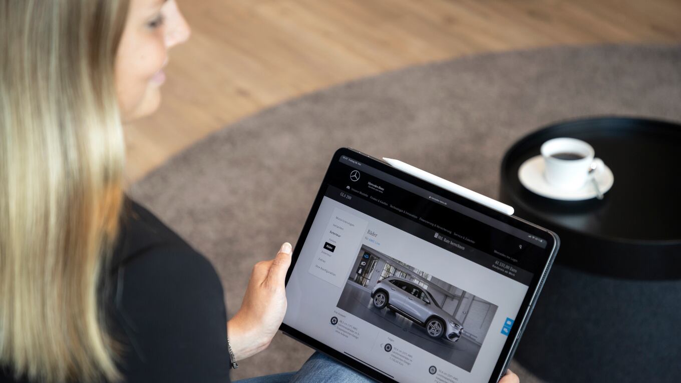 Eine Frau konfiguriert ein Auto mit Hilfe des Mercedes Benz Fahrzeug Konfigurators.